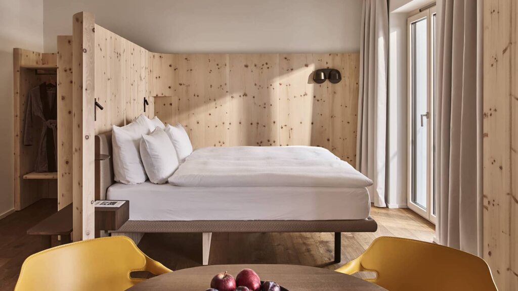 Gemütlicher Schlafbereich des Lofts mit Doppelbett, Holzwand und Tageslicht