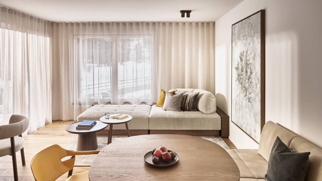 Wohnbereich im 2 Bedroom Apartment mit Esstisch, Sitzecke und großen Fenstern