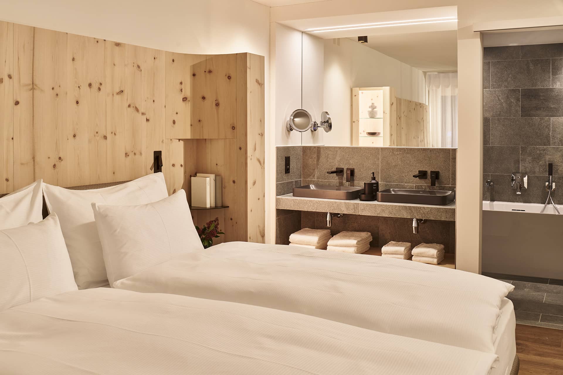 Offenes Badezimmer im Apartment mit Doppelwaschbecken, Natursteinoberflächen und Spiegeln