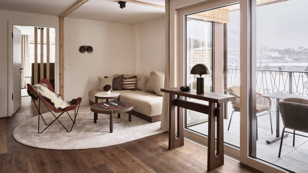 Wohnbereich der Residence 2 mit Sofa, Lounge-Sessel und Zugang zum Balkon