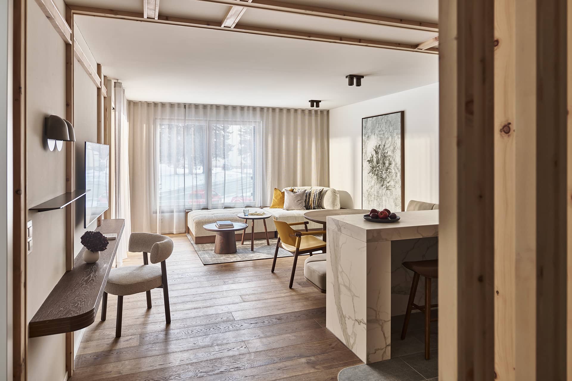 Offener Wohnbereich der Suite 2 mit Sofa, Esstisch, Kücheninsel und bodentiefen Fenstern