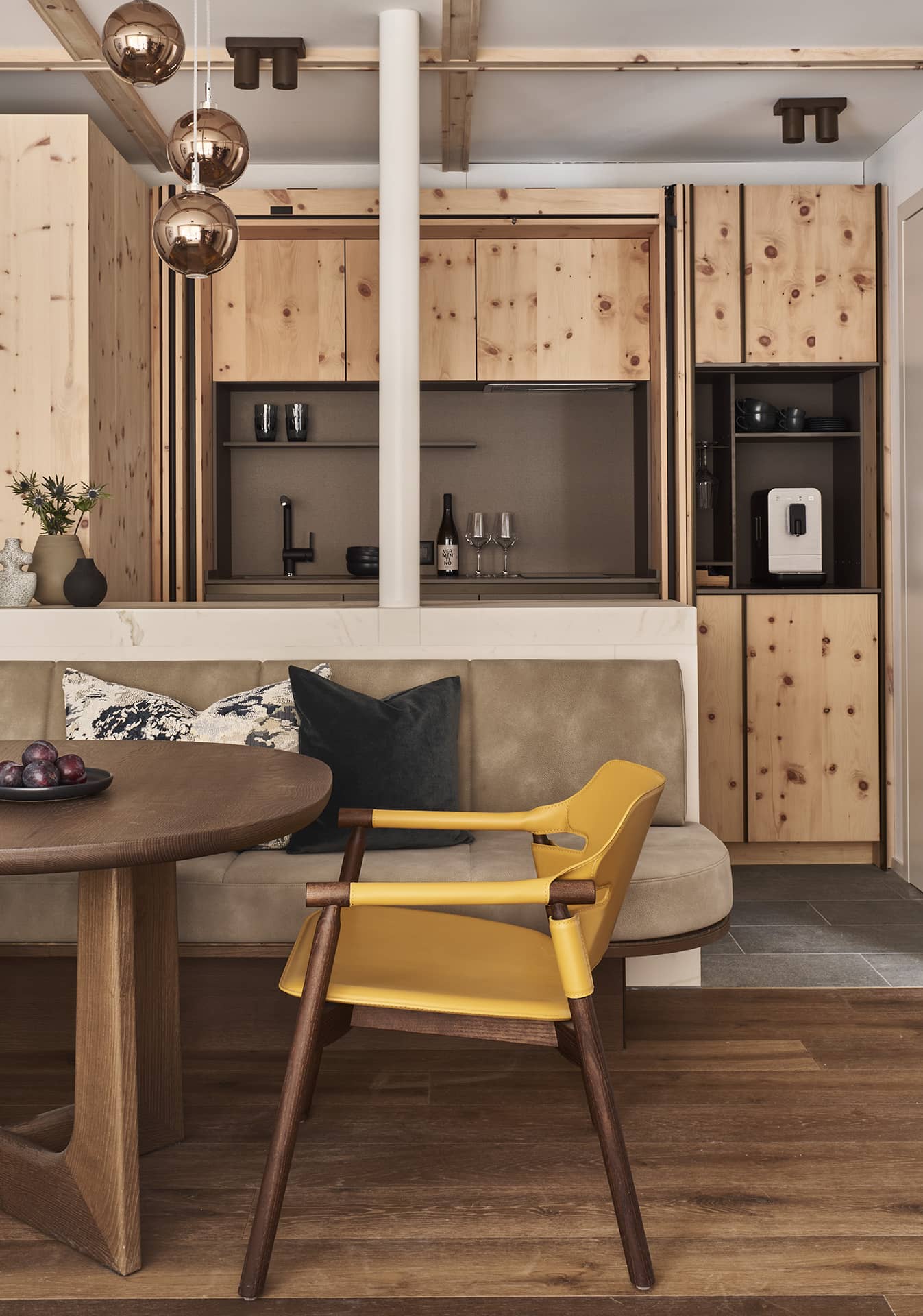 Essbereich der Suite mit Holztisch, gepolsterter Sitzbank und integrierter Küchenzeile