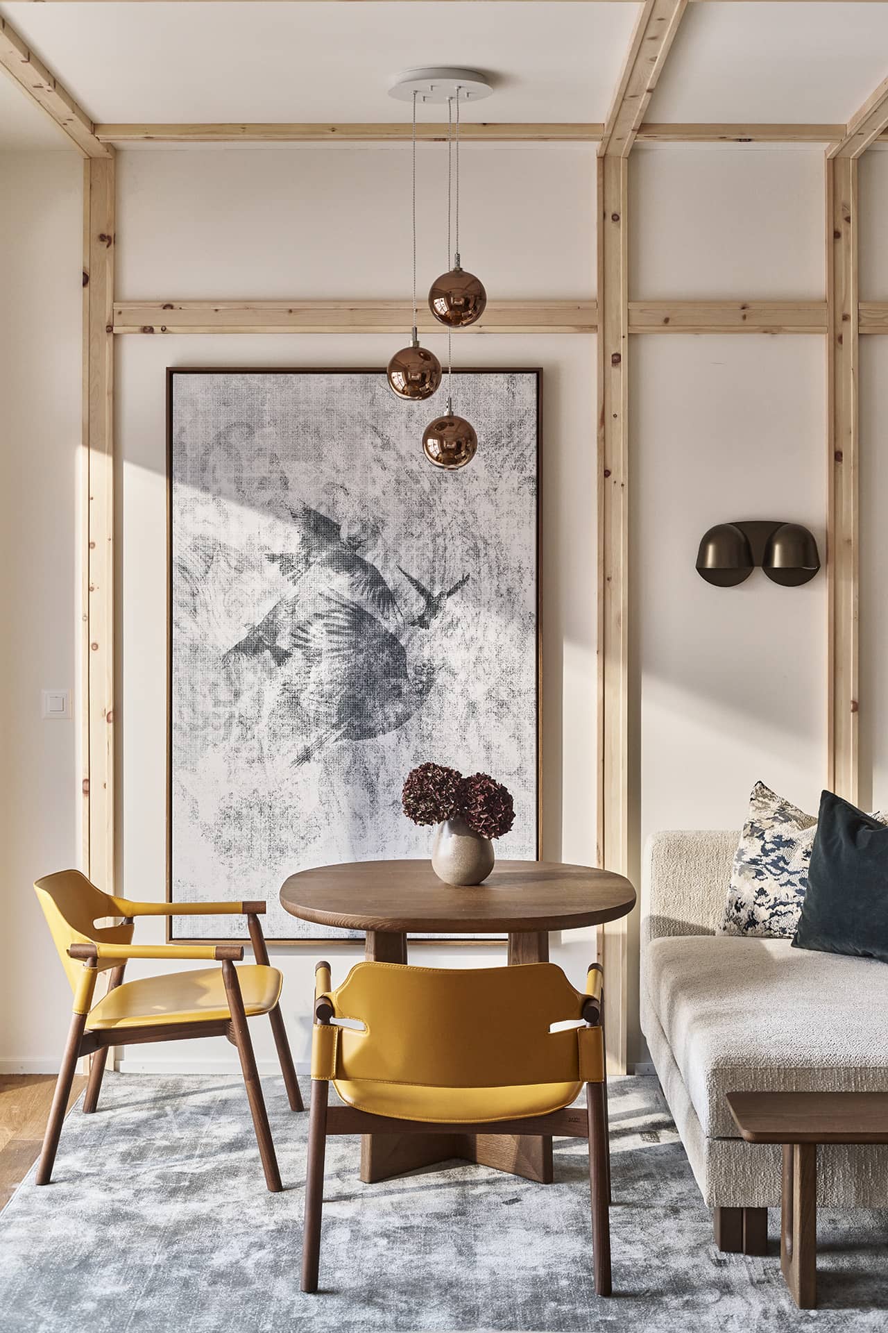 Essbereich im Loft mit Designstühlen, rundem Tisch und großformatigem Kunstwerk an der Wand.