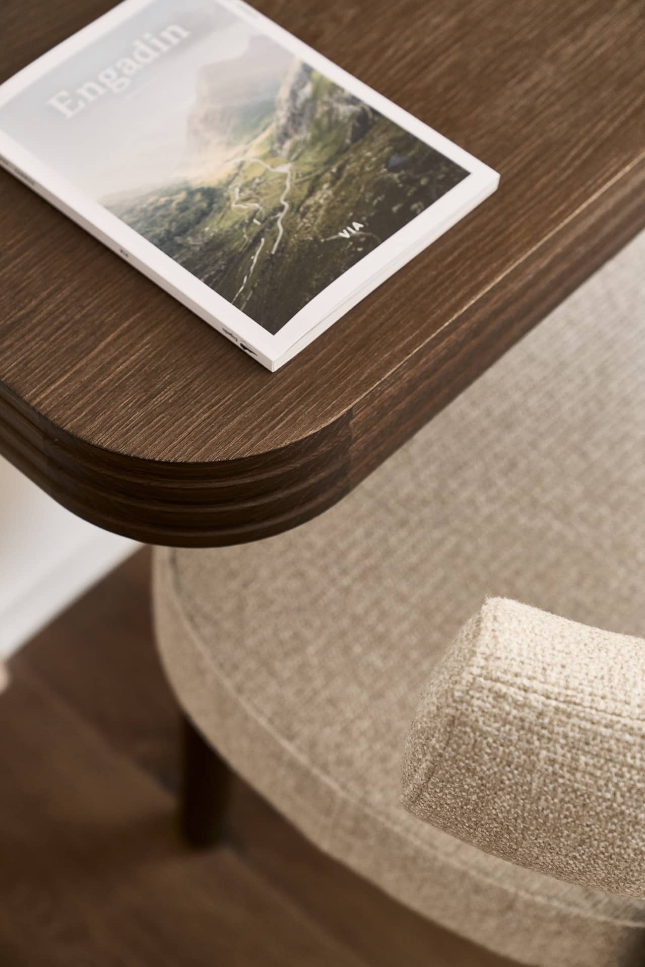 Detailaufnahme eines Beistelltisches im Loft mit Engadin-Magazin auf einer eleganten Holzoberfläche.