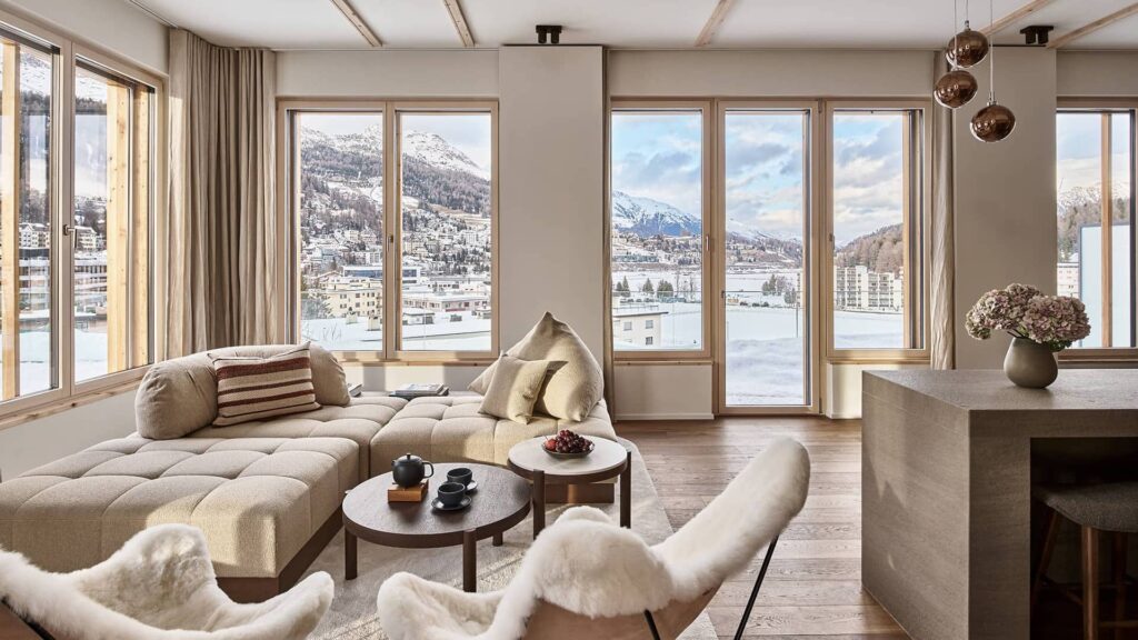 Open living area of the master penthouse with comfortable seating, an open kitchen, and a view through floor-to-ceiling windows