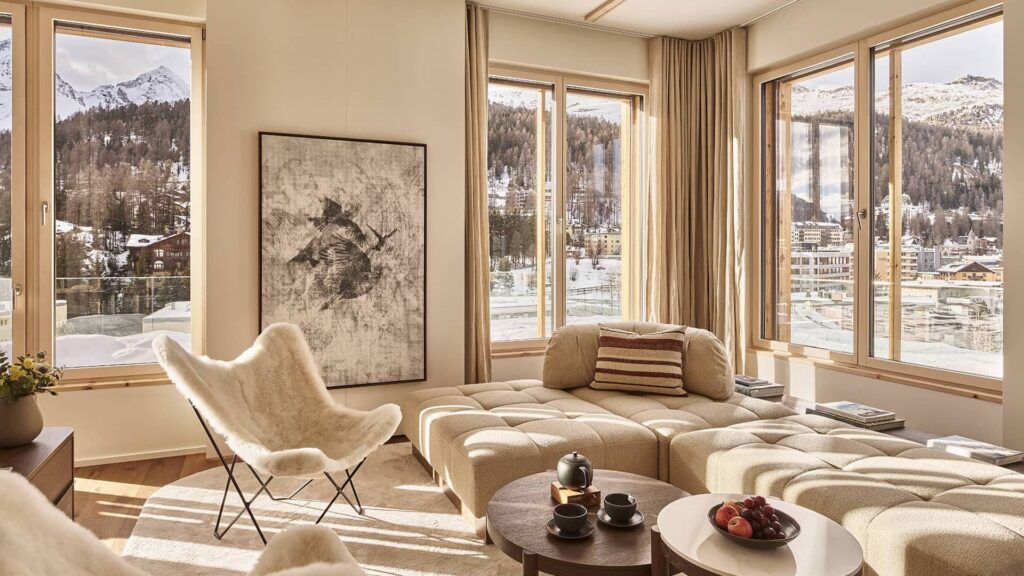 Open living area of the 3-bedroom penthouse with comfortable seating and a view through floor-to-ceiling windows
